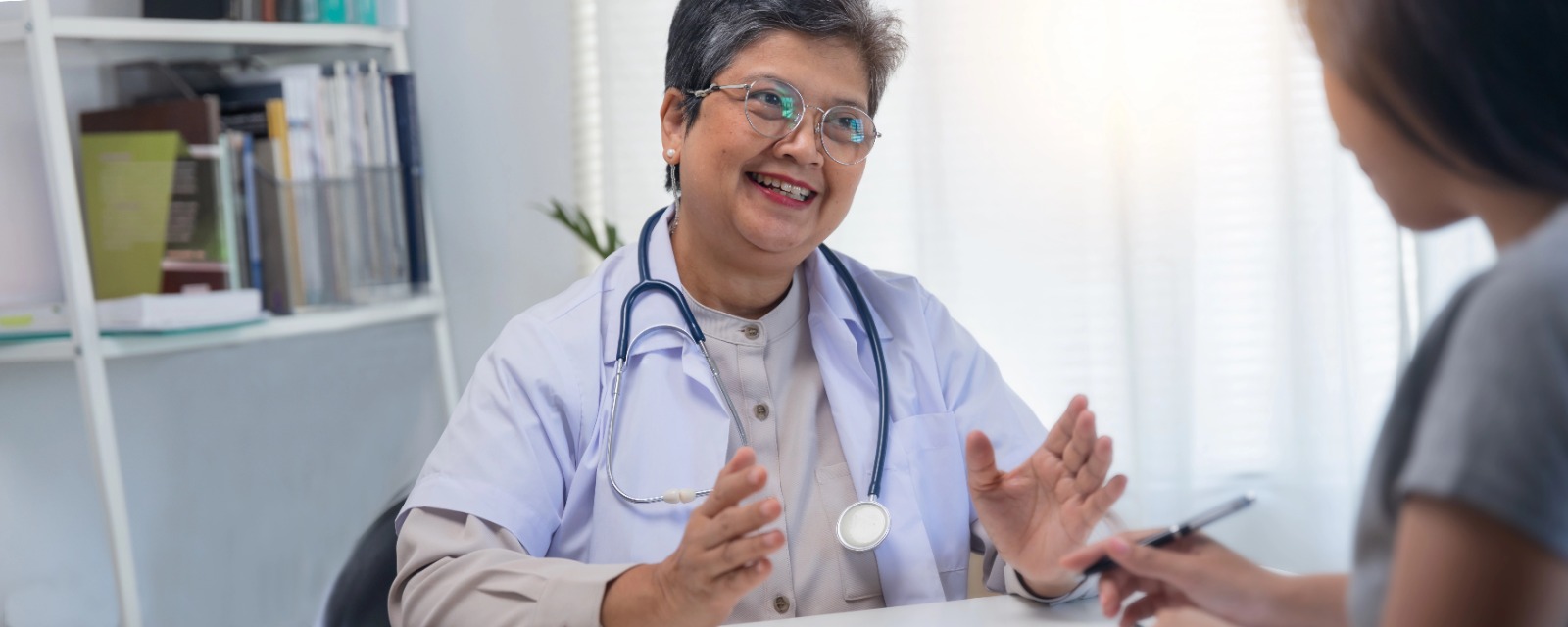 Smiling female doctor in consultation with patient, symbolizing trust and healthcare education - in this blog post HPV vaccine.