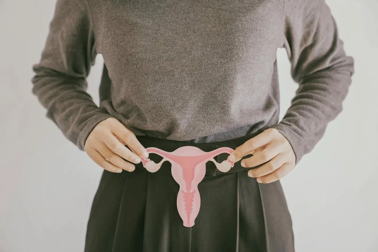 Close-up of woman holding an ovary and uterus cutout to highlight PCOS awareness and reproductive health.