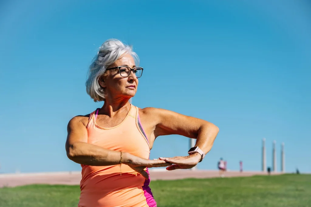 Active senior woman stretching outdoors in bright sunlight, promoting joint health and wellness with Ashwagandha in MILY supplement.