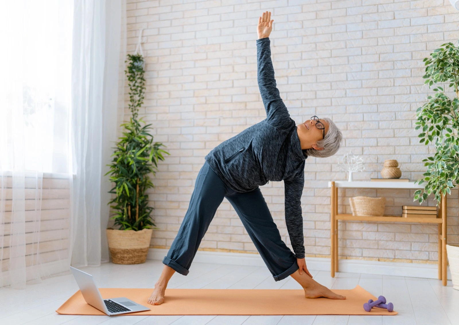 Senior woman practicing yoga at home for better mobility and heart health during menopause.