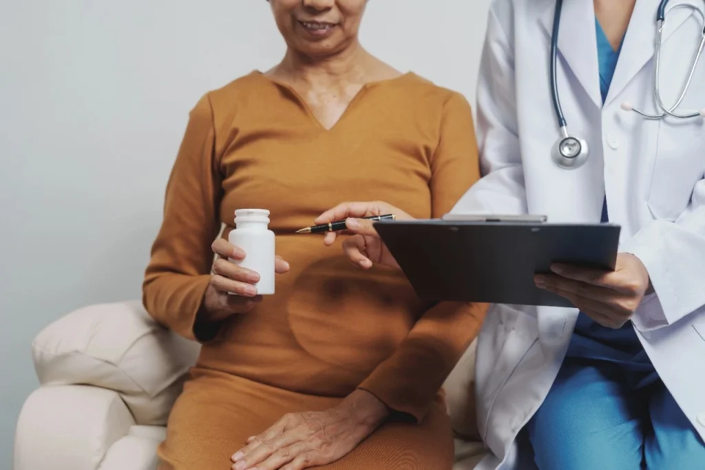 Indian woman discussing hormone replacement therapy (HRT) options with female doctor during menopause consultation in India.