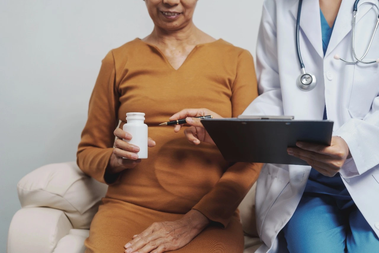 Indian woman discussing hormone replacement therapy (HRT) options with female doctor during menopause consultation in India.