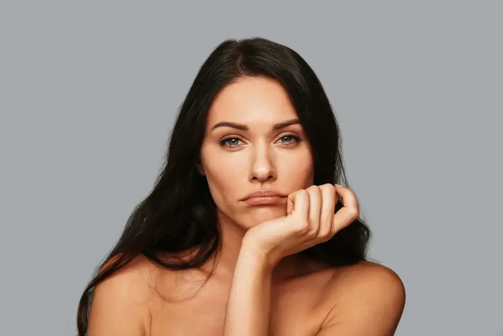 Woman showing emotional fatigue and low energy linked to symptoms of low estrogen in women including brain fog, mood changes, and hormonal imbalance.