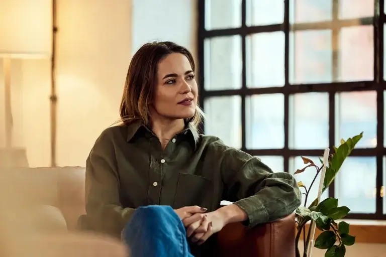Woman in her 40s seated by a window, representing hormonal balance and natural ways to increase estrogen levels in females