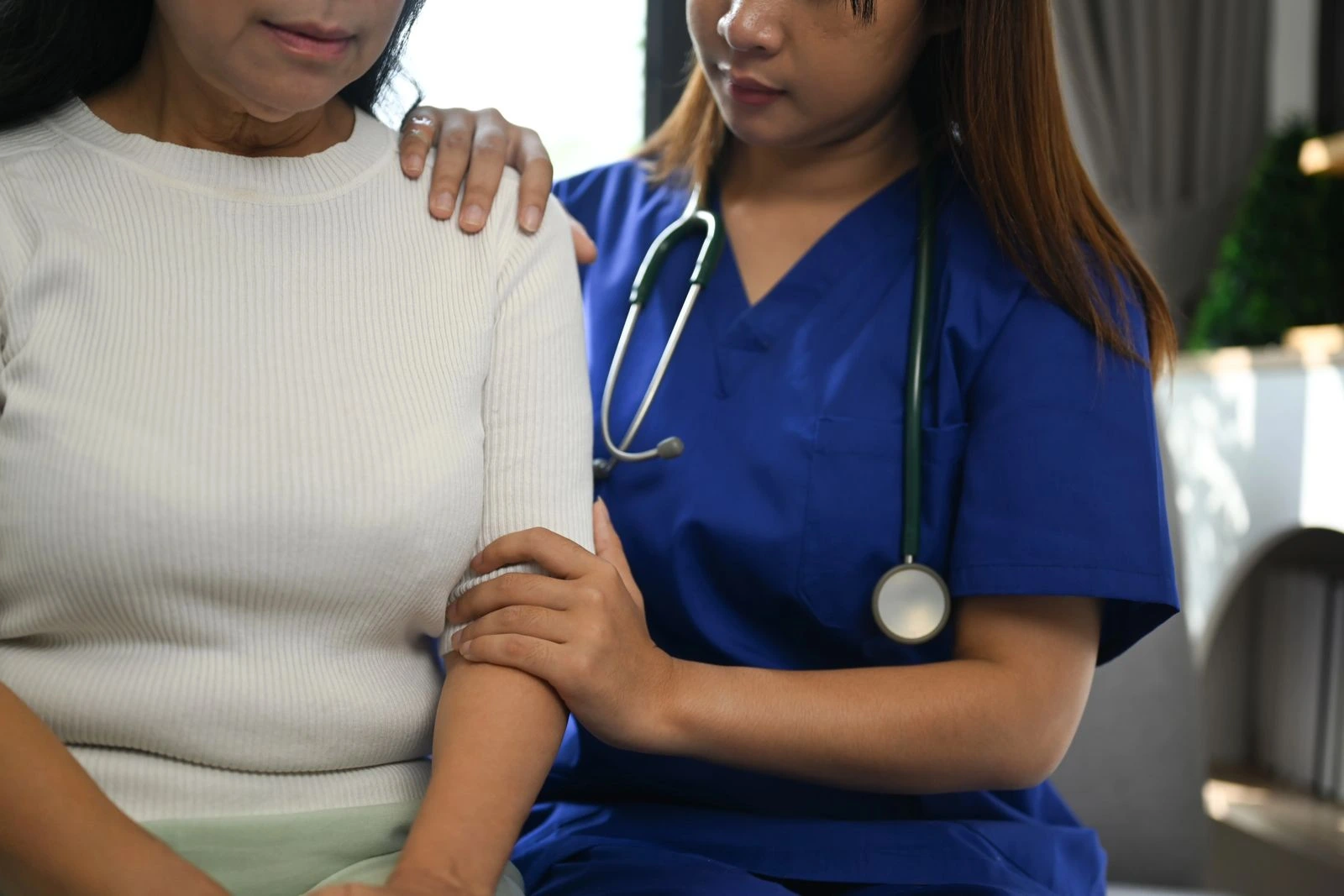 Healthcare professional comforting a menopausal woman during a medical consultation about menopausal hormone therapy and women’s midlife health.