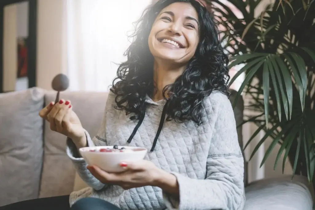 Woman over 40 enjoying a protein-rich breakfast bowl at home, supporting muscle health, metabolism, and hormonal balance