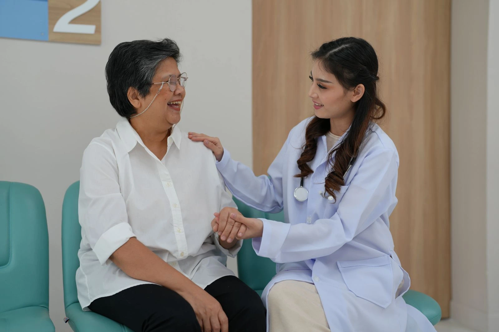 Senior woman consulting with female doctor about menopausal hormone therapy and long term women’s health care in a clinical setting