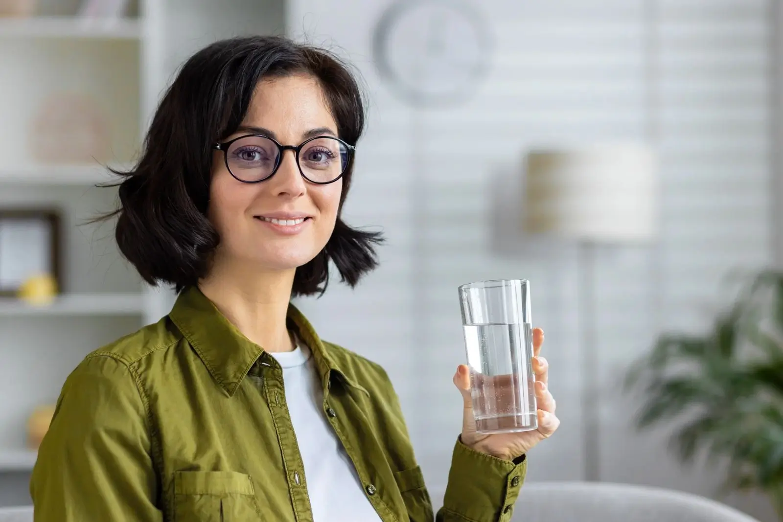 Midlife woman in her 40s holding a glass of water, highlighting hydration and electrolyte balance for women over 40.