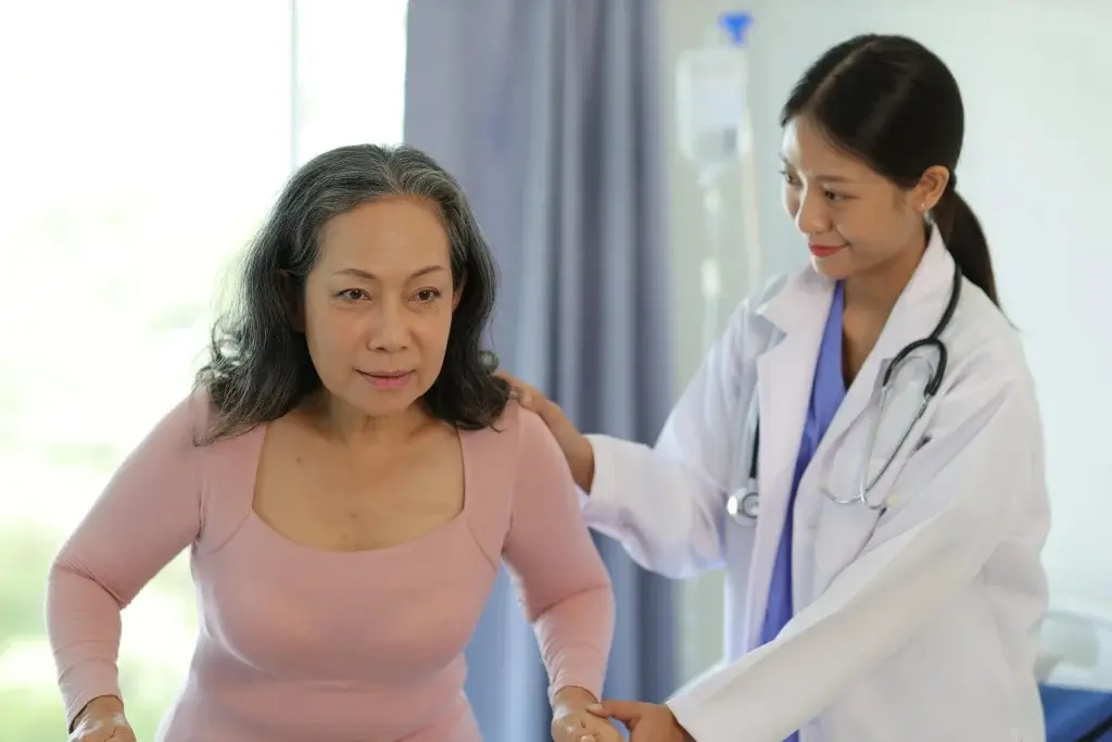 Postmenopausal osteoporosis treatment consultation showing a doctor assessing bone health and posture in a woman after menopause