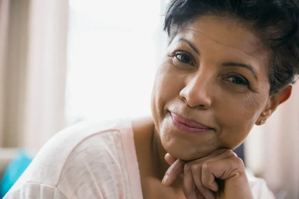 Treatment for hot flashes in midlife woman reflecting indoors in natural light