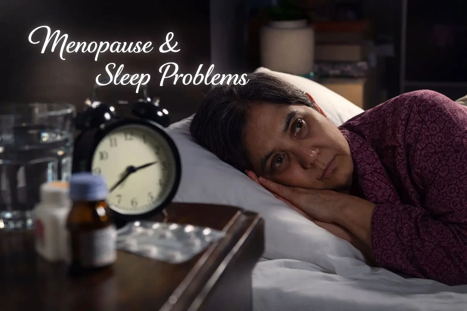 Sleep problems menopause showing older Indian woman with insomnia lying awake at night beside alarm clock