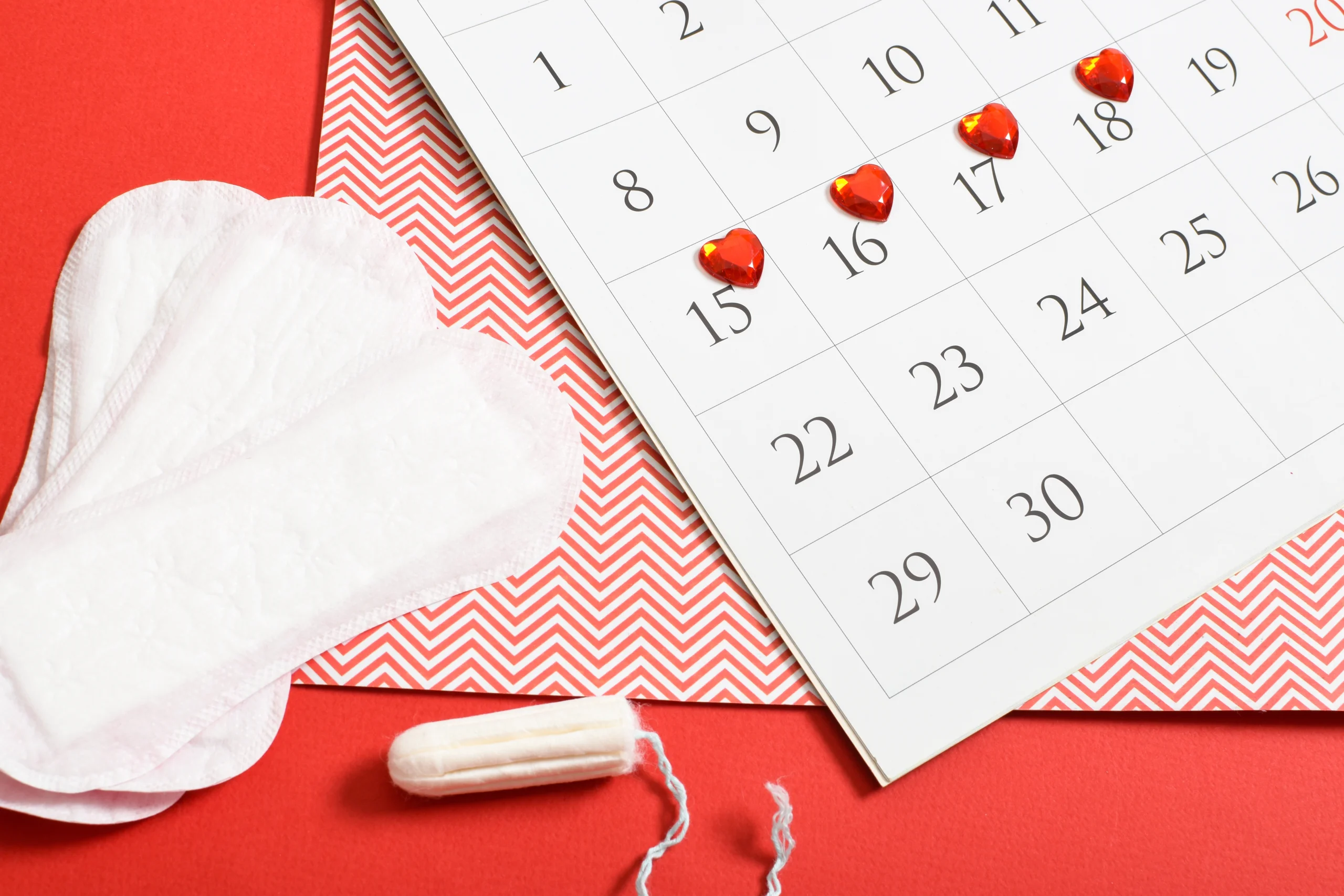 Menstrual cycle phases in perimenopause shown with calendar markings, blood drops, and sanitary pads representing irregular periods and hormonal changes