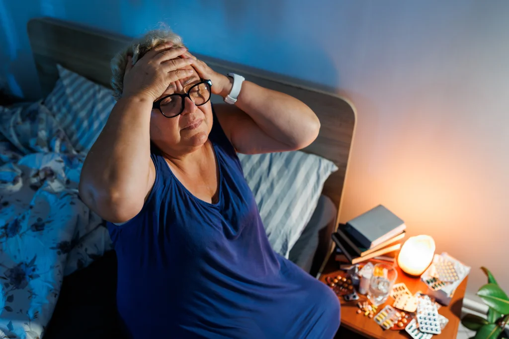 Indian woman in her 40s awake at night experiencing menopause insomnia and difficulty sleeping.